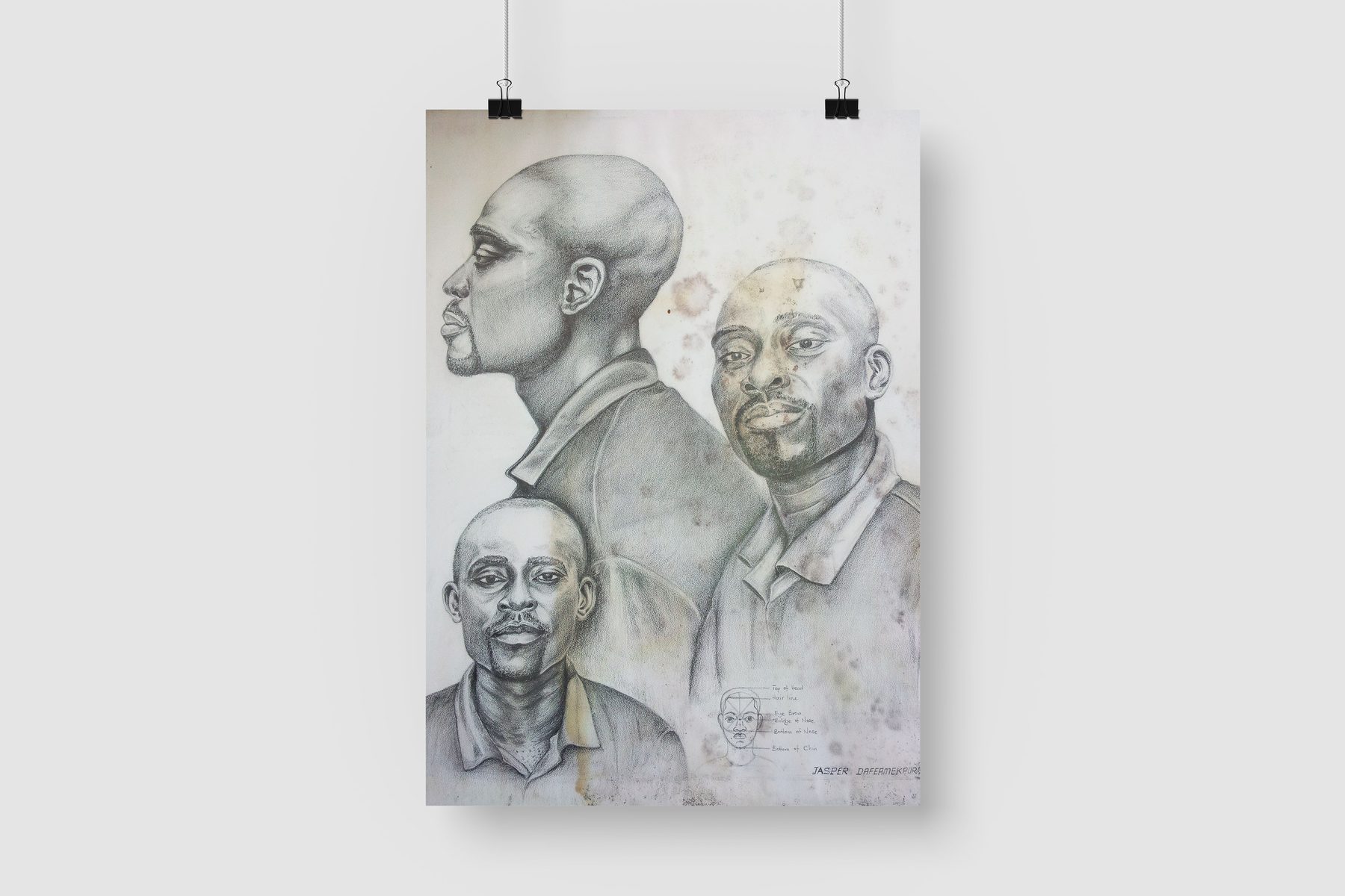 Pencil self-portrait drawing showing three heads, displayed as a print hung on a wall