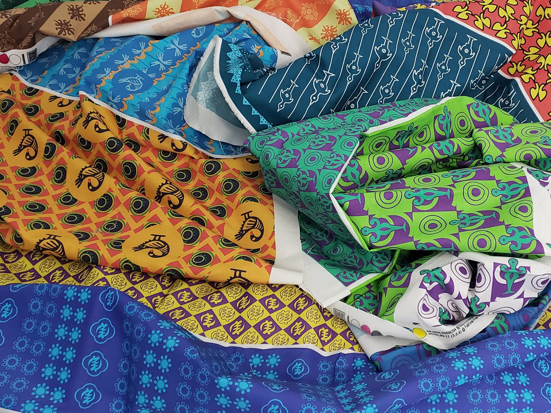 Lessons from Granny fabrics printed with Anlo-Ewe and Adinkra symbols, piled in folds